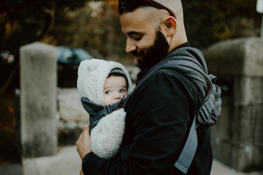 Photo of dad looking at baby in carrier