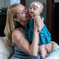 Seated mom smiling at baby