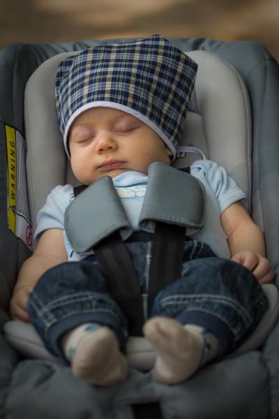 Photo of sleeping baby in car seat