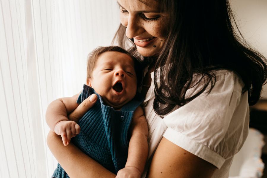 Photo of yawning baby with mom